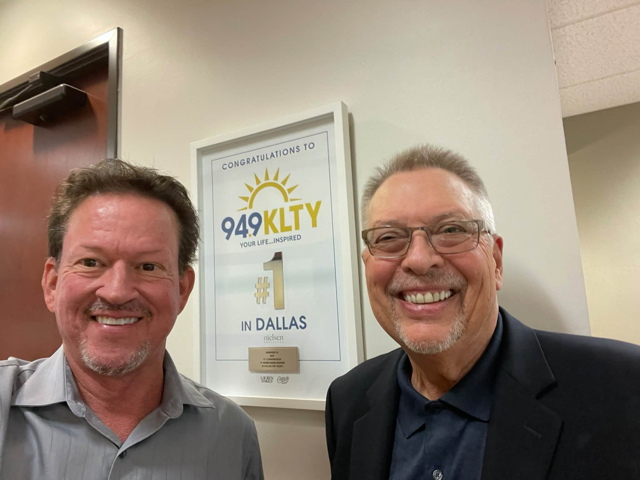 Frank beside KLTY’s framed recognition
